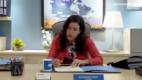 Exasperated woman sitting at a desk throwing a document over her shoulder